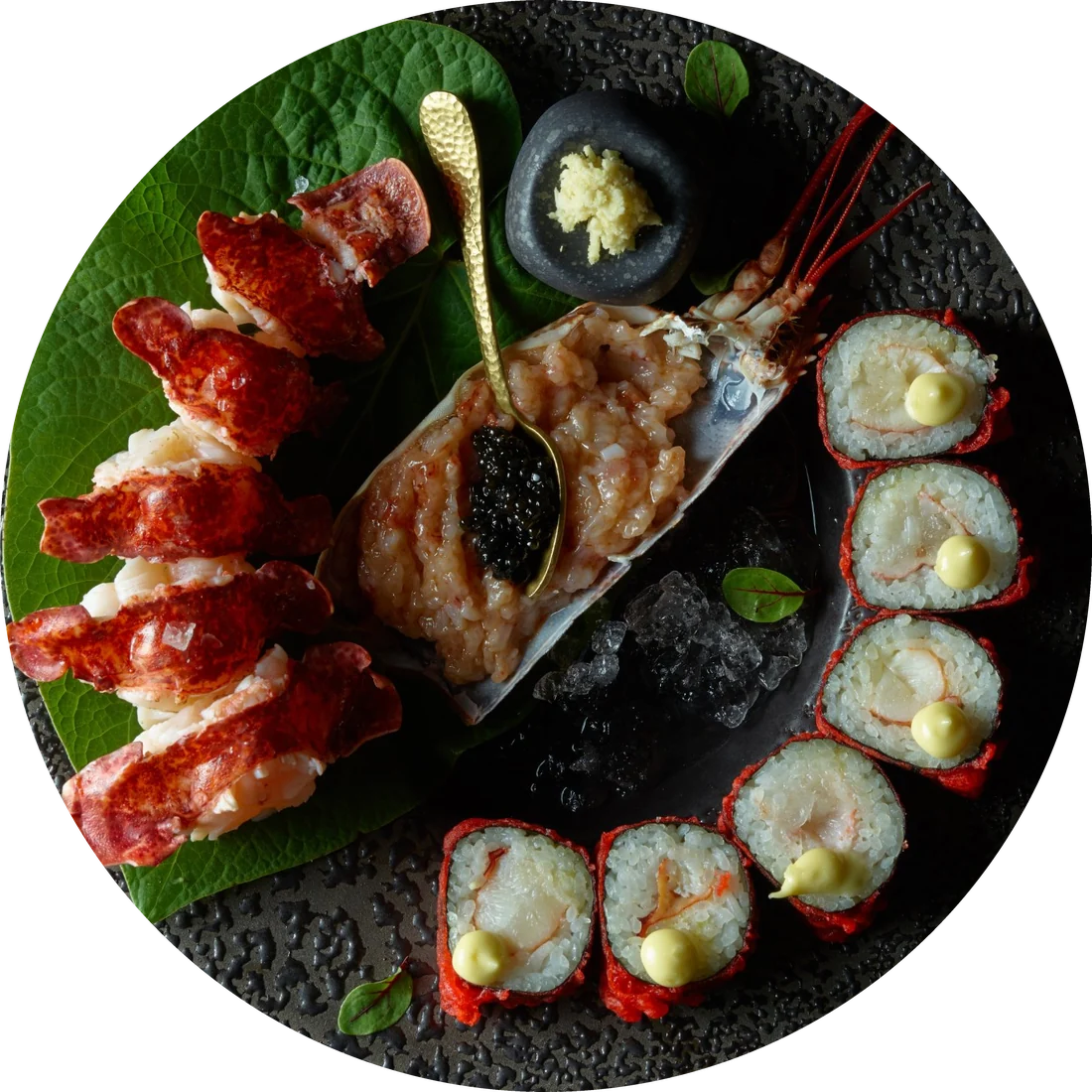 Plato de mariscos de Abya: langosta, tartar con caviar y rolls sobre un plato negro